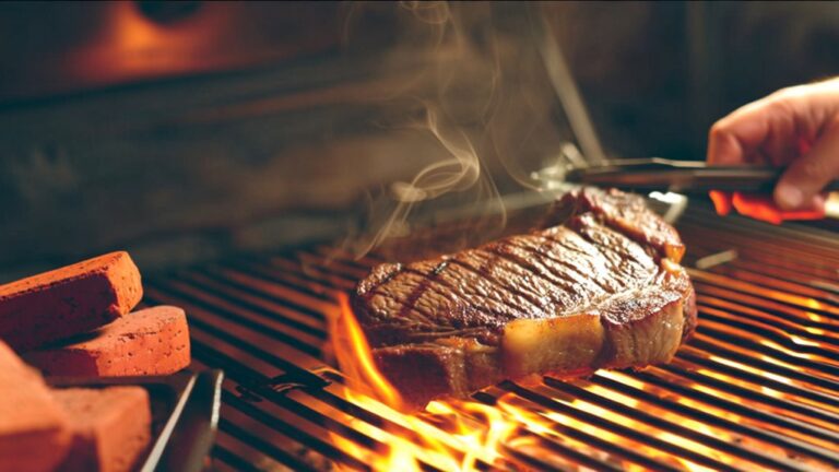 cooking steak on charcoal